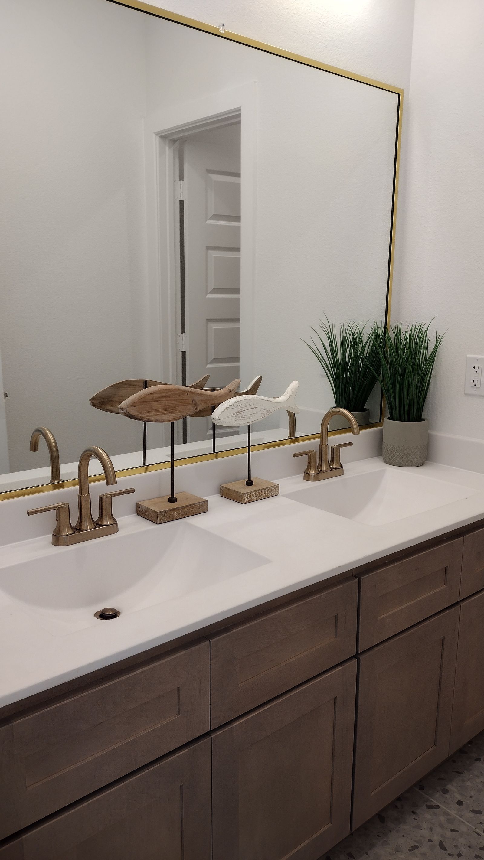 Double bathroom vanity with white sinks and brass-toned faucets